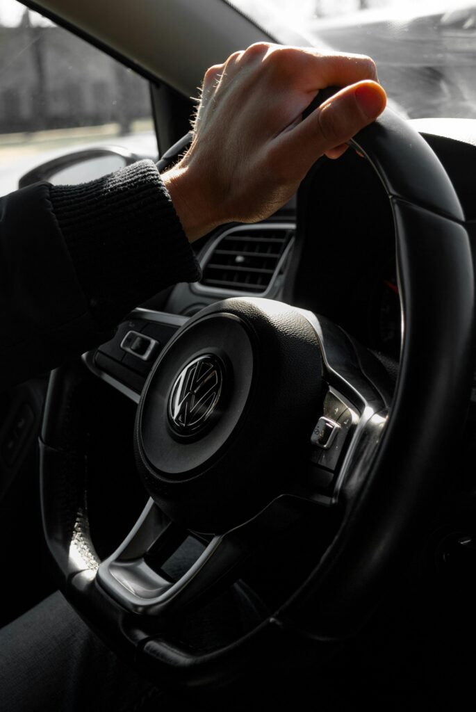 pexels-photo-32124512-32124512 A detailed view of a hand gripping a car's steering wheel, capturing driving essence.